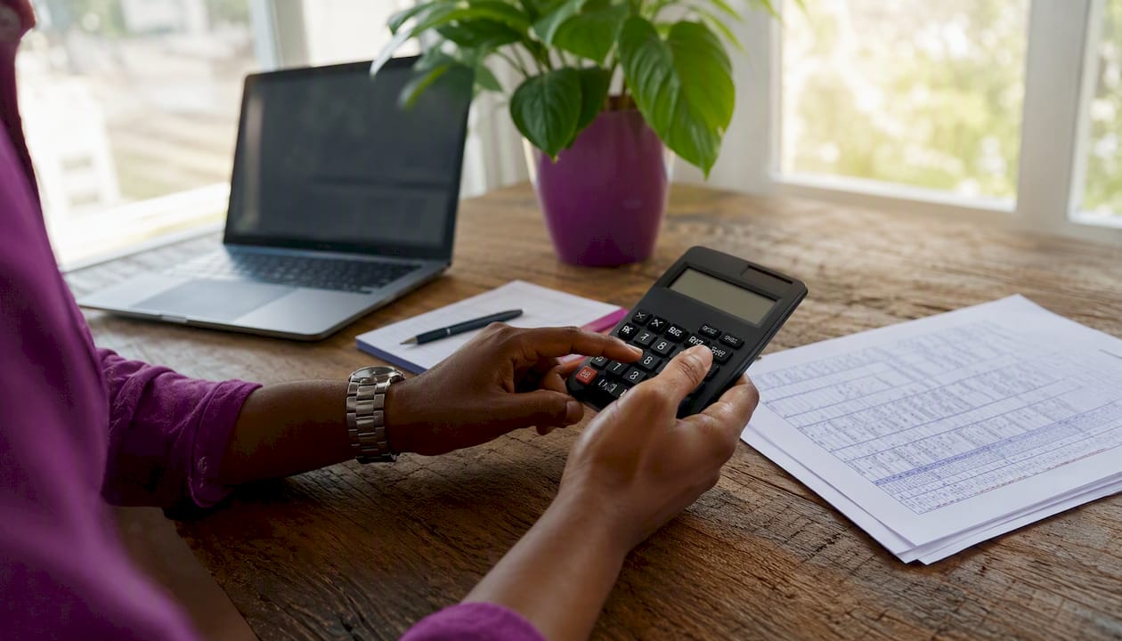Hands calculating Nigerian WHT rates with table