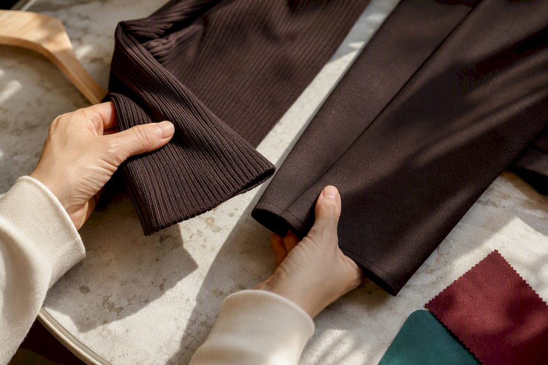 Hands comparing knit and ponte fabric textures