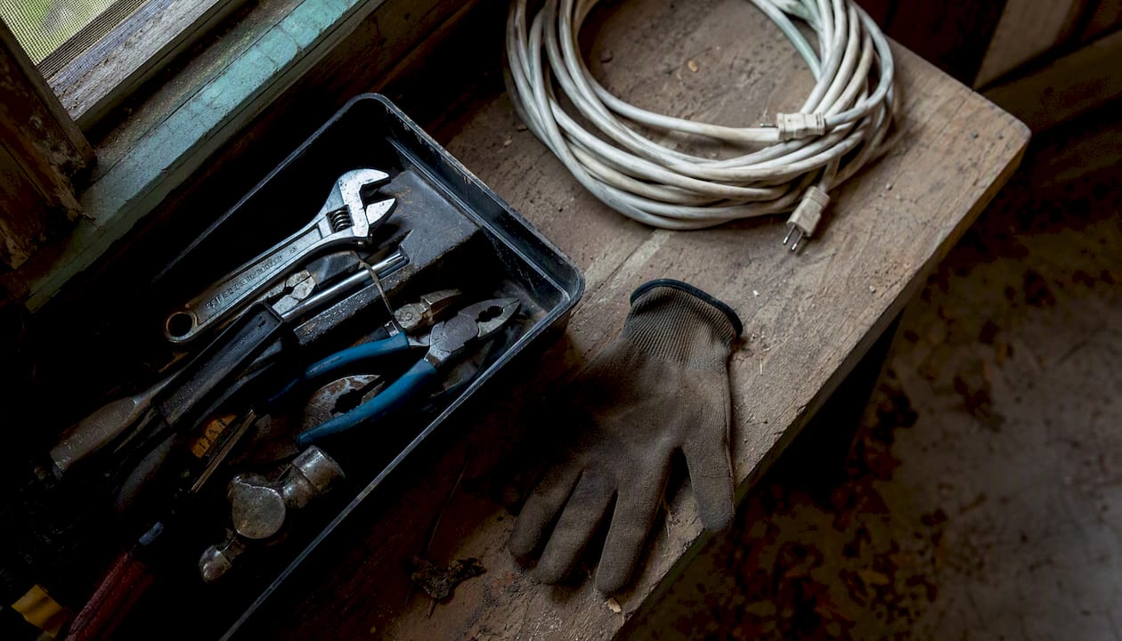 Work gloves and tools on wooden bench
