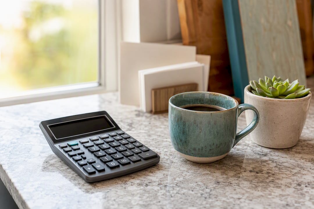 Calculator and coffee mug on wooden desk