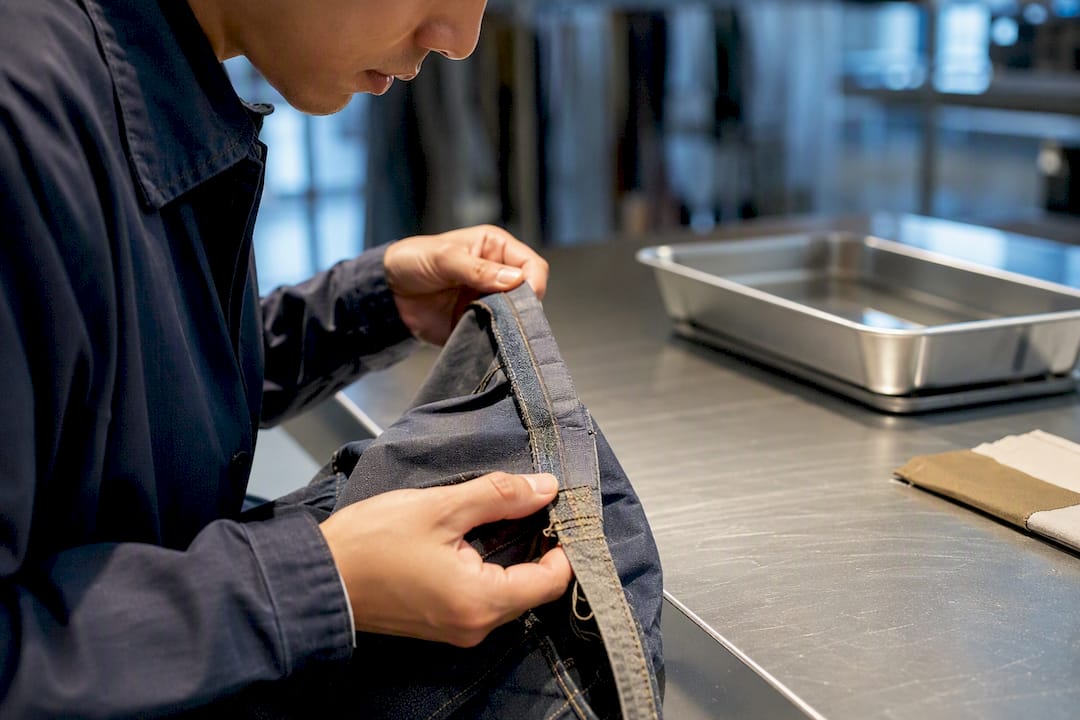 Technician inspecting dyed garment seam