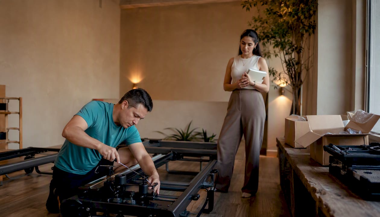 A technician installs equipment in a Pilates studio that is about to open.