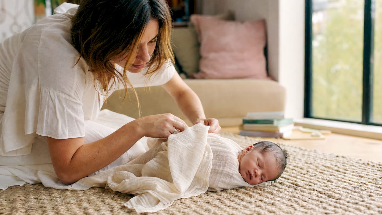 Newborn resting near window in bedroom