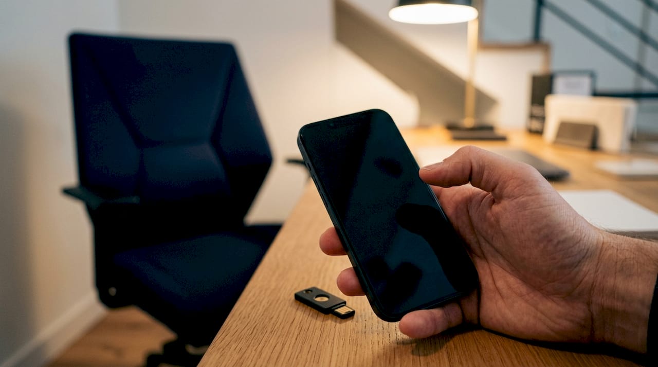 Eine Hand hält ein Smartphone bereit, um eine vertrauliche Hinweisgeber-Meldung abzuschicken.