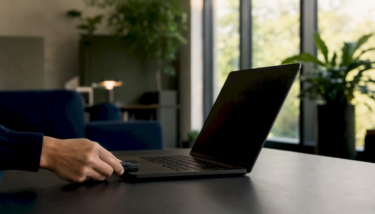 Eine Hand steckt einen USB-Sicherheitsschlüssel in den Laptop.