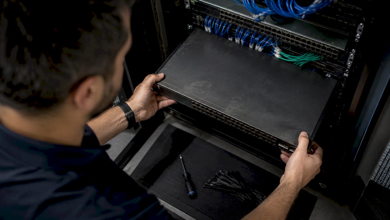 Technician installing network switch hardware