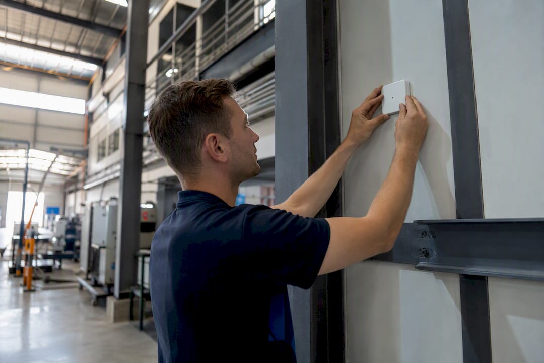 Technology blocks: a modular building‑block guide for IT leaders - Re-solution Hands installing RTLS sensor in factory