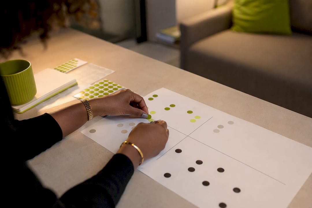 Hands applying colored stickers to persona matrix