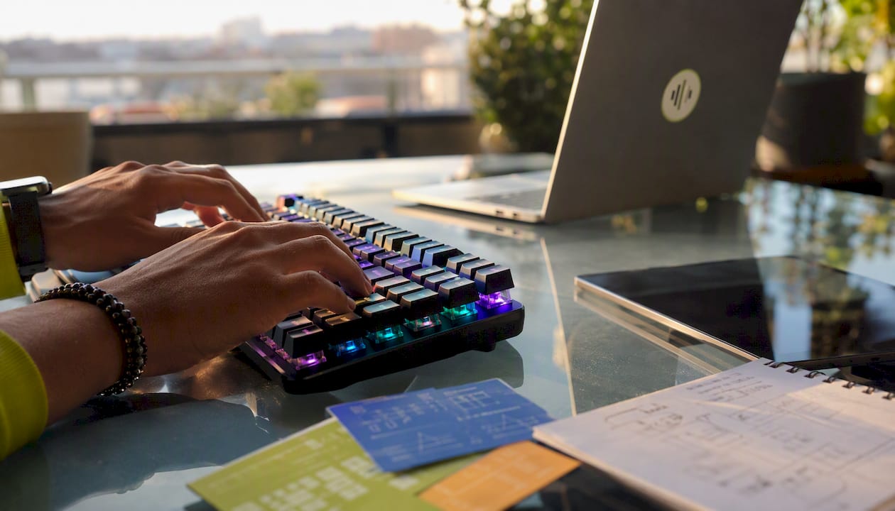 Close-up on hands typing API code with reference cards