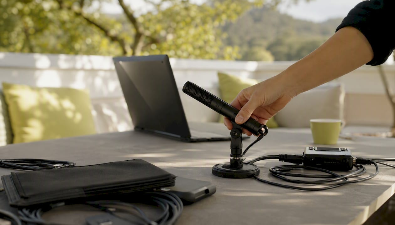 Hand placing microphone in meeting setup