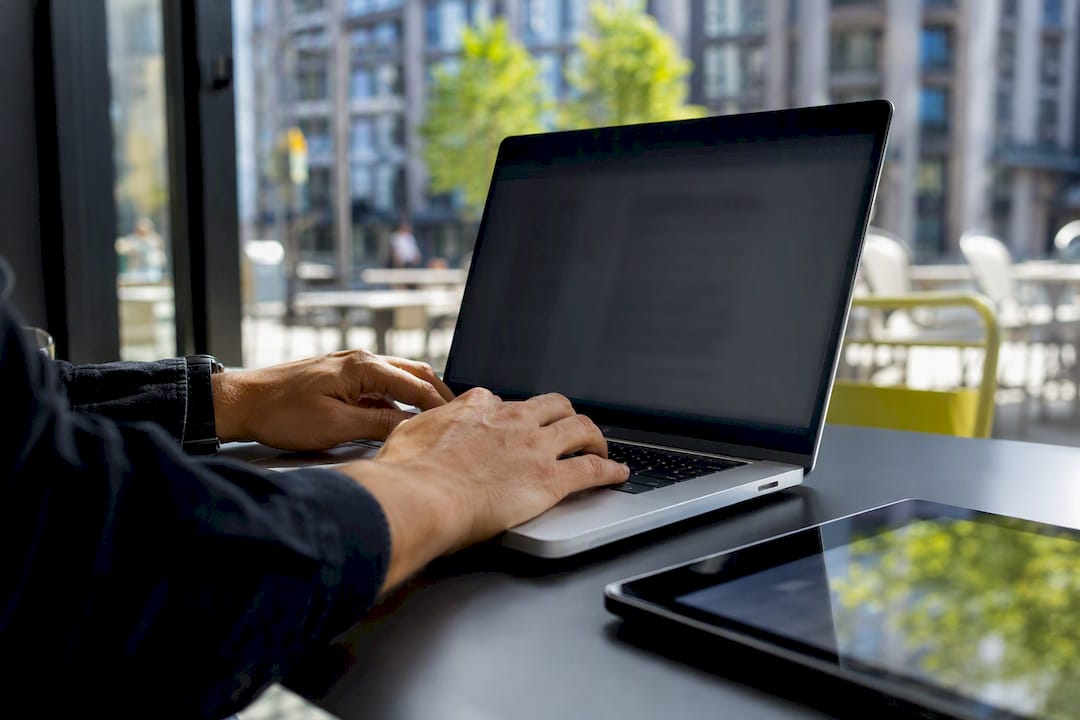 Hands holding tablet with glowing screen outdoors