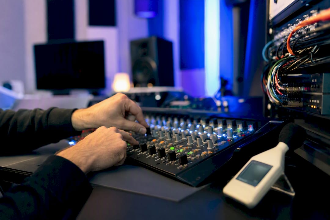 Hands adjusting audio interface knob in acoustic lab
