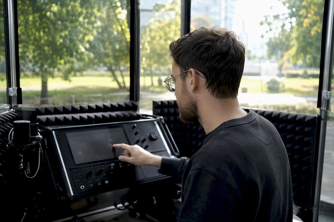 Hands adjusting noise suppression device in booth