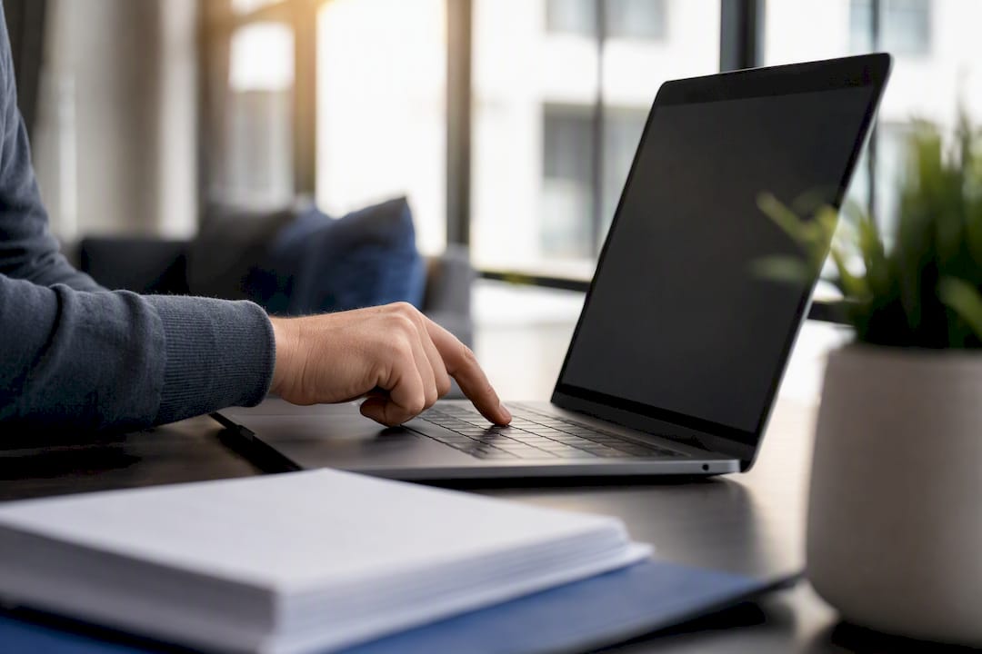 Hand sending real estate offer email on laptop