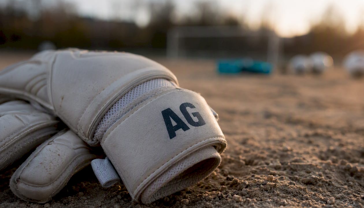 Detailaufnahme des Handgelenkbandes eines Torwarthandschuhs mit aufgedruckten Initialen