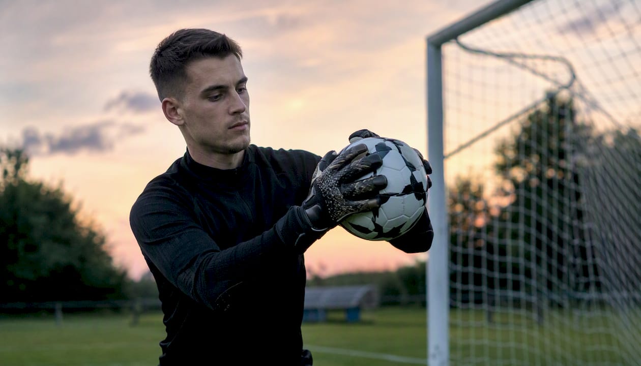 Torwart fängt den Ball sicher mit der W-Handhaltung.