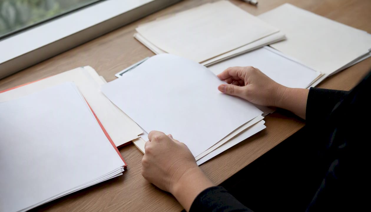 Hands sorting PGx billing documents