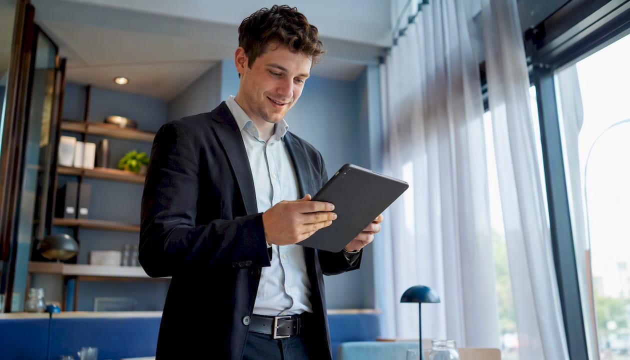 Der Restaurantleiter überprüft die digitale Arbeitszeiterfassung auf seinem Smartphone.