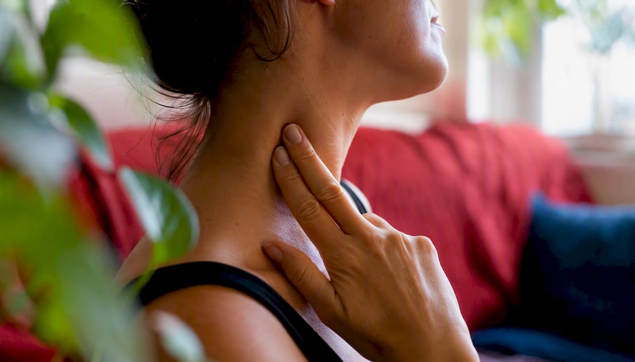 Close-up of hands sensing shoulder muscle tension