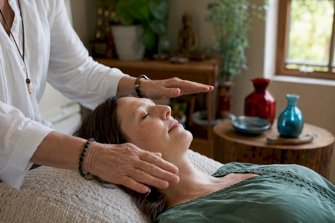 Hands performing energy healing during QHHT session