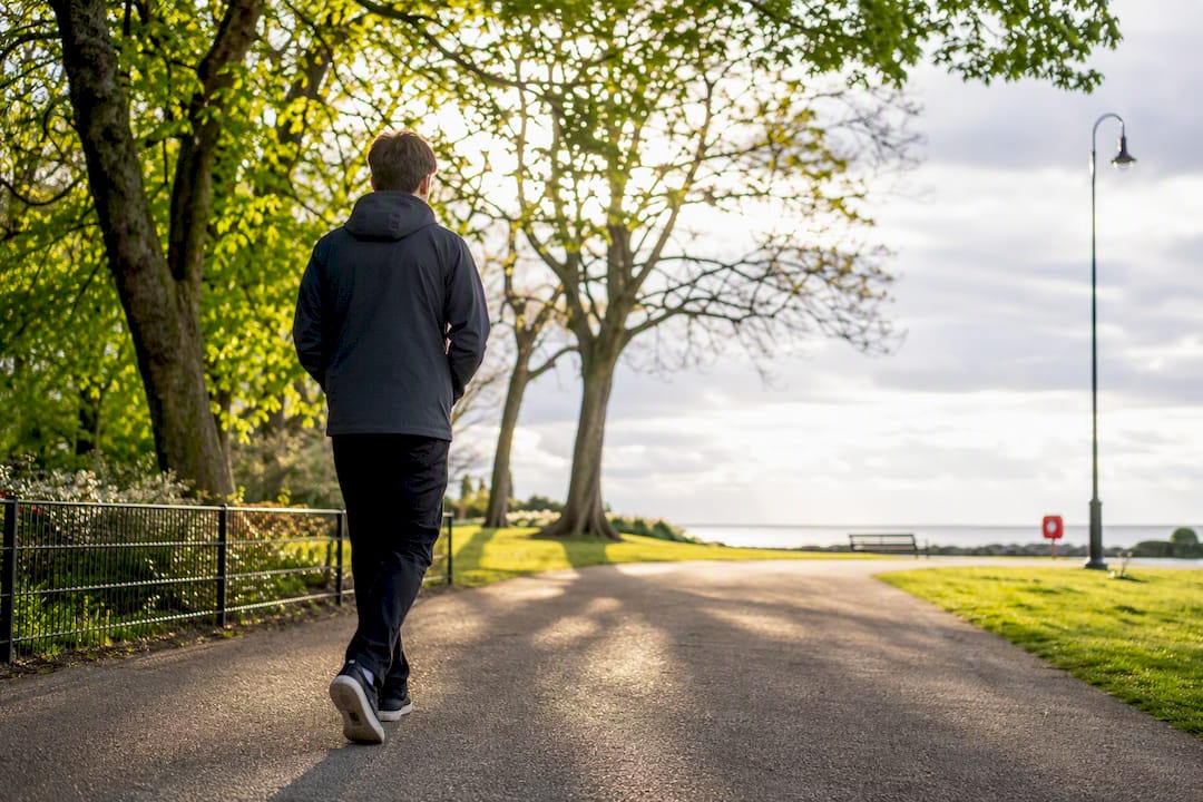 Adult taking a purposeful walk in a park