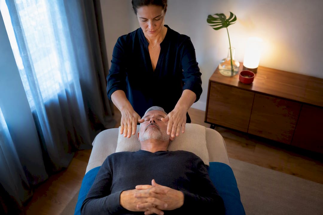 Practitioner performing Reiki over clothed client