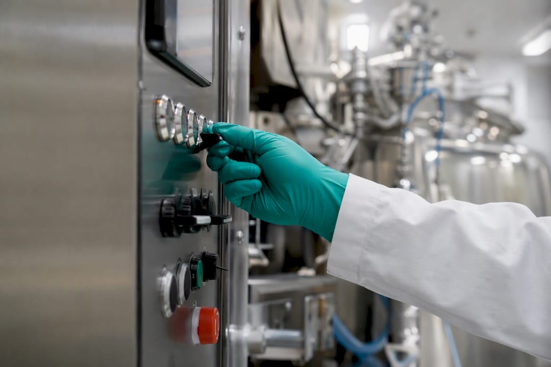 Gloved hand on automated validation control panel