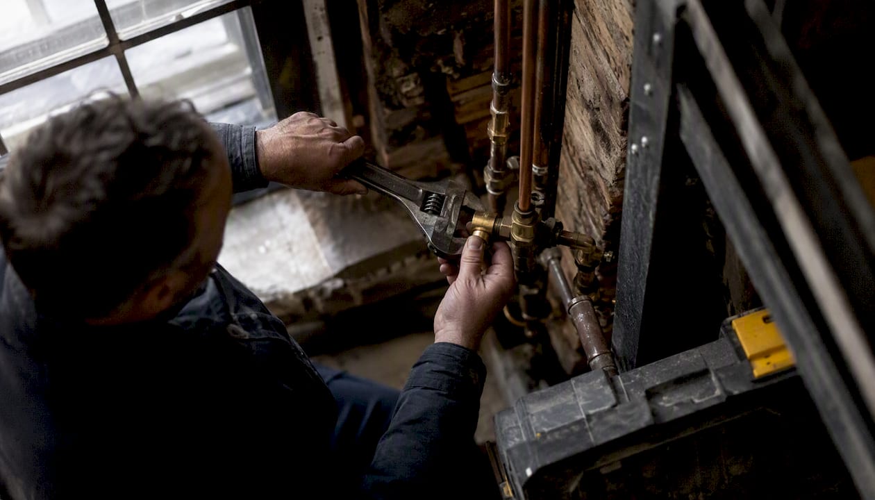 Technician hands tightening pipe fitting