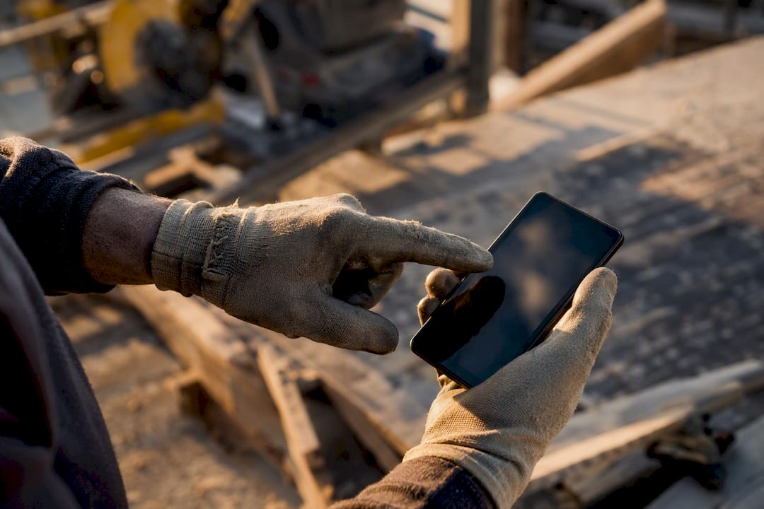 Technician hands uploading job photo on mobile