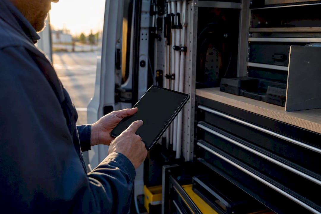 Technician hands holding dark tablet in service van
