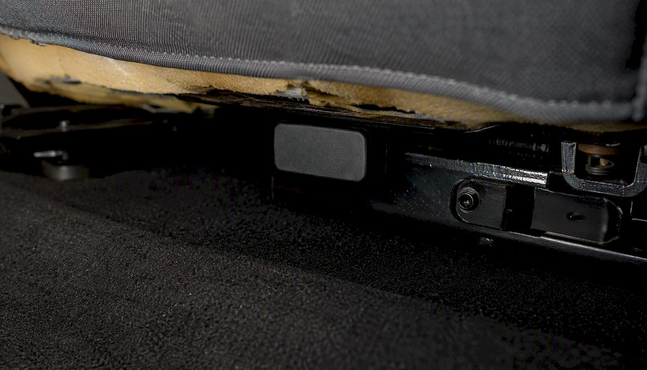 GPS tracker magnetically mounted under car seat rail