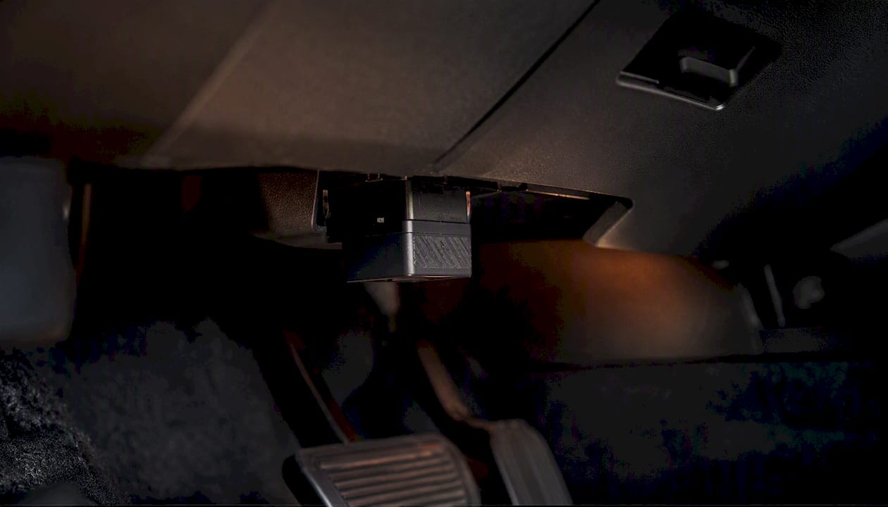 Plug-in OBD tracker installed under dashboard