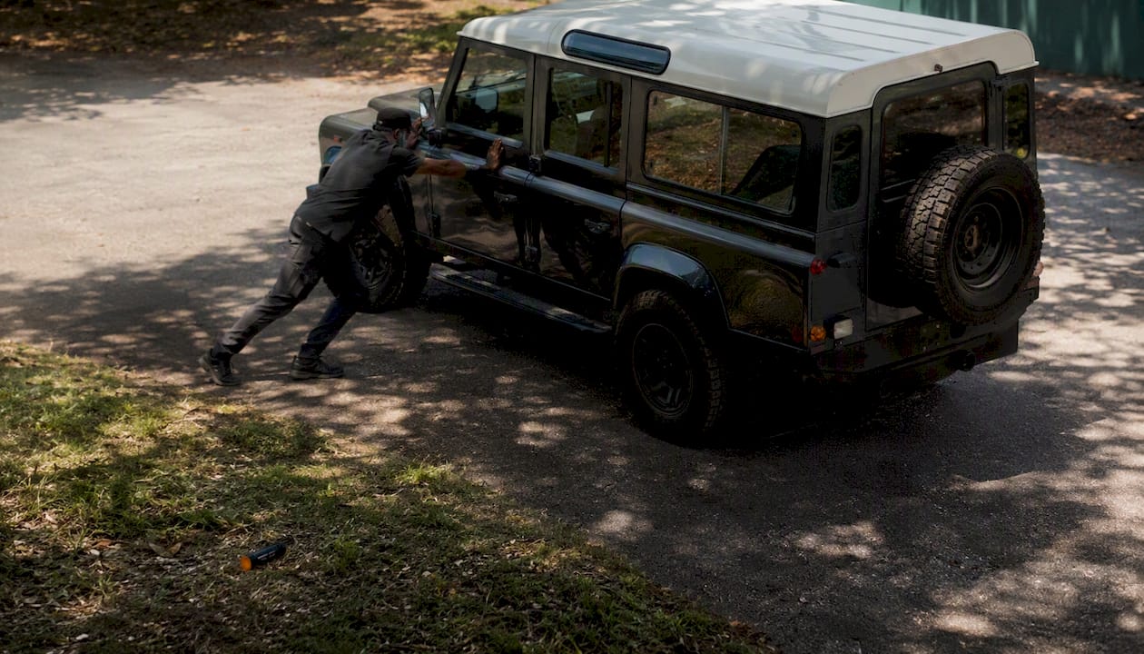 Hands gently rocking Land Rover for tamper test