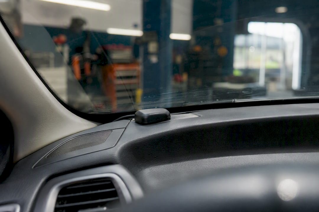 GPS antenna on car dashboard under coated windshield
