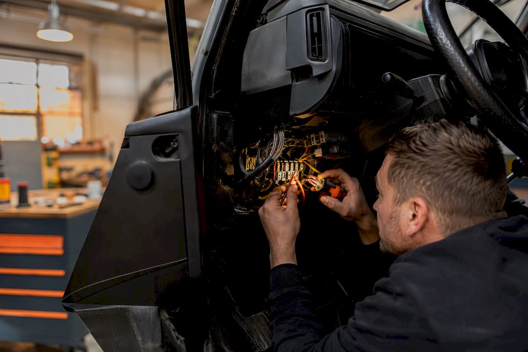Hands examining vehicle tracker wiring
