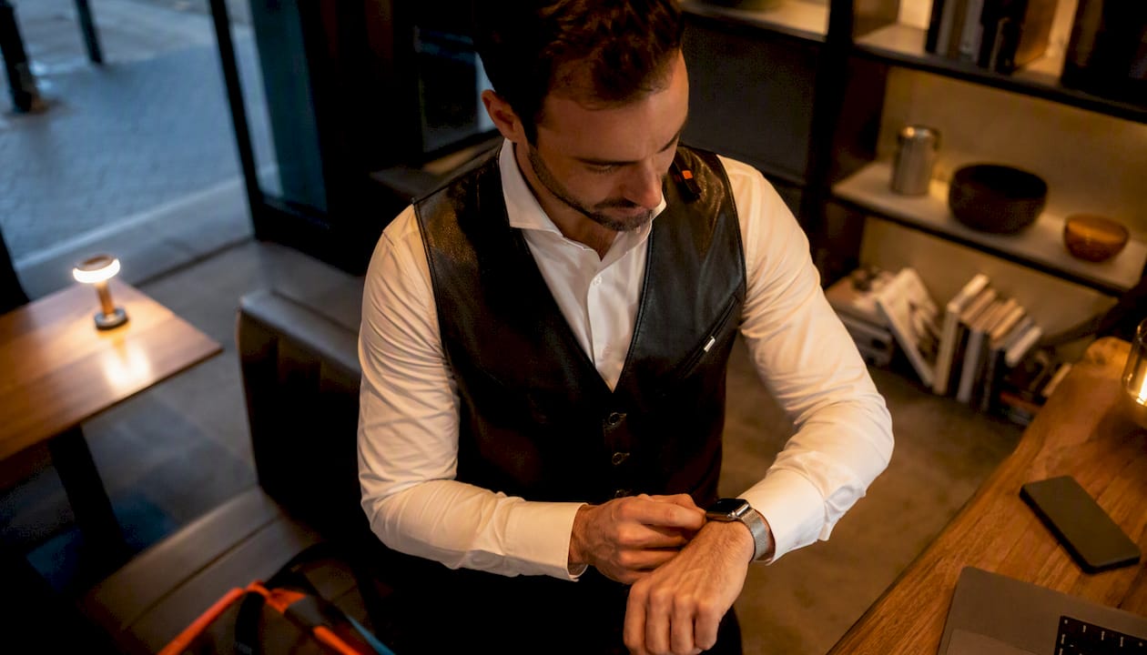 Un homme règle le bracelet en acier milanais de son Apple Watch