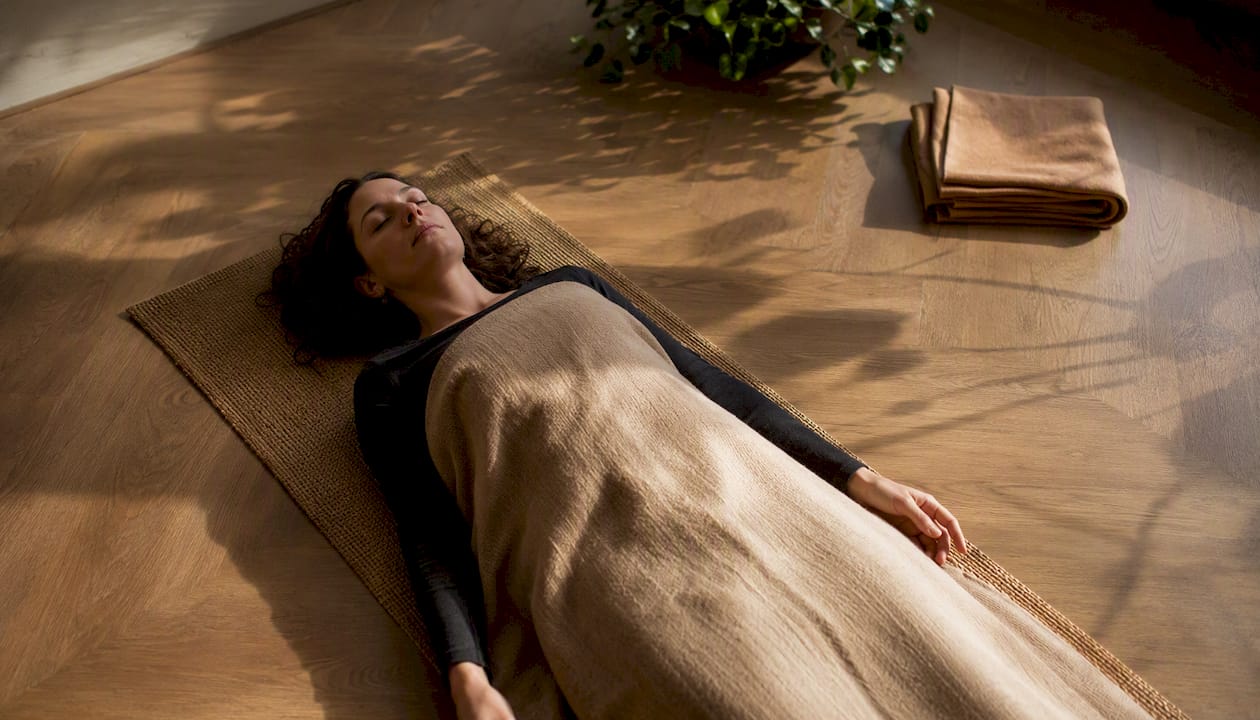 Une personne allongée, en train de pratiquer une relaxation guidée par un scan corporel.