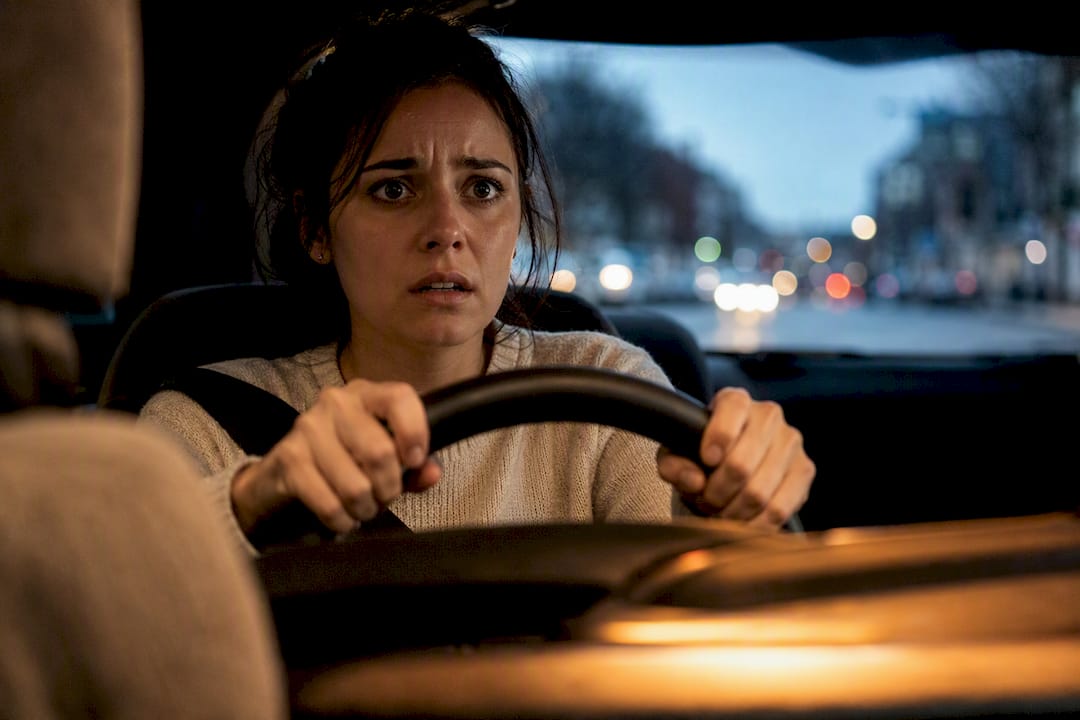 Femme au volant, visiblement stressée