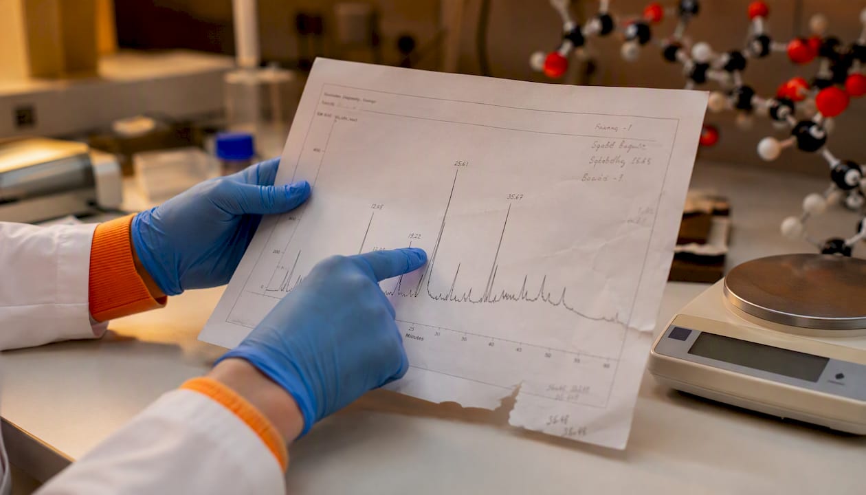 Een ervaren laborant neemt het HPLC-chromatogram nauwkeurig onder de loep.
