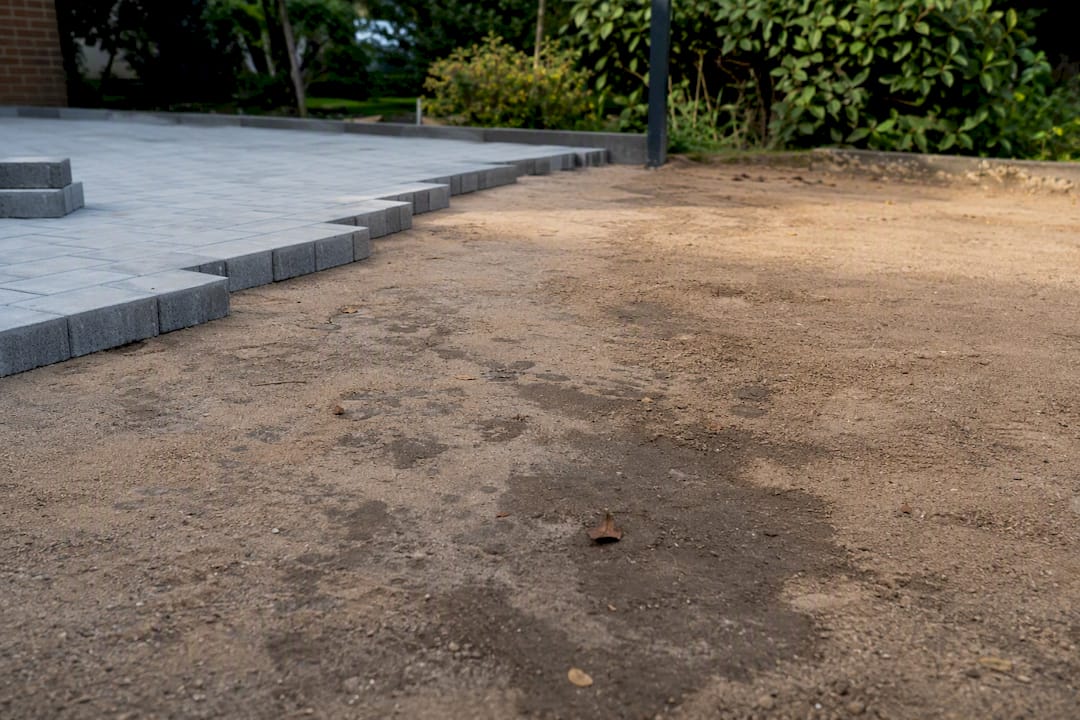 Sandiger, wasserdurchlässiger Boden neben Pflastersteinen