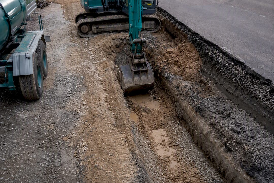 Bagger legt Bodenschichten bei Straßenbau frei