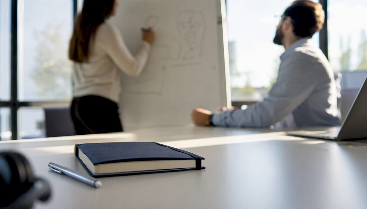 Workspace with notebook and headset for sales training