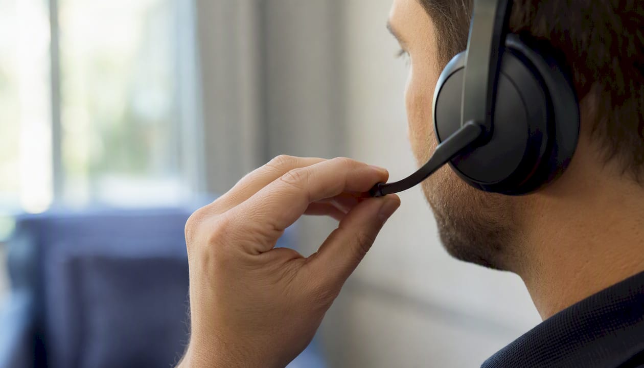 Hands adjusting headset microphone