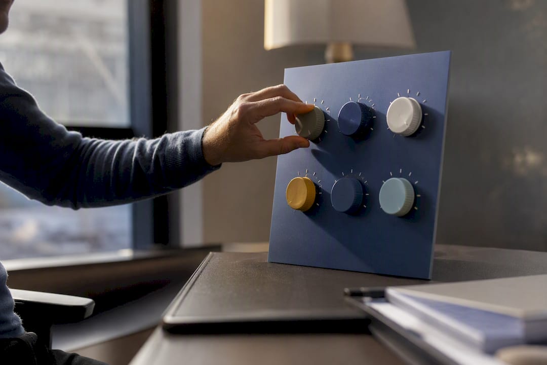 Hand adjusting control dial on blue dashboard panel