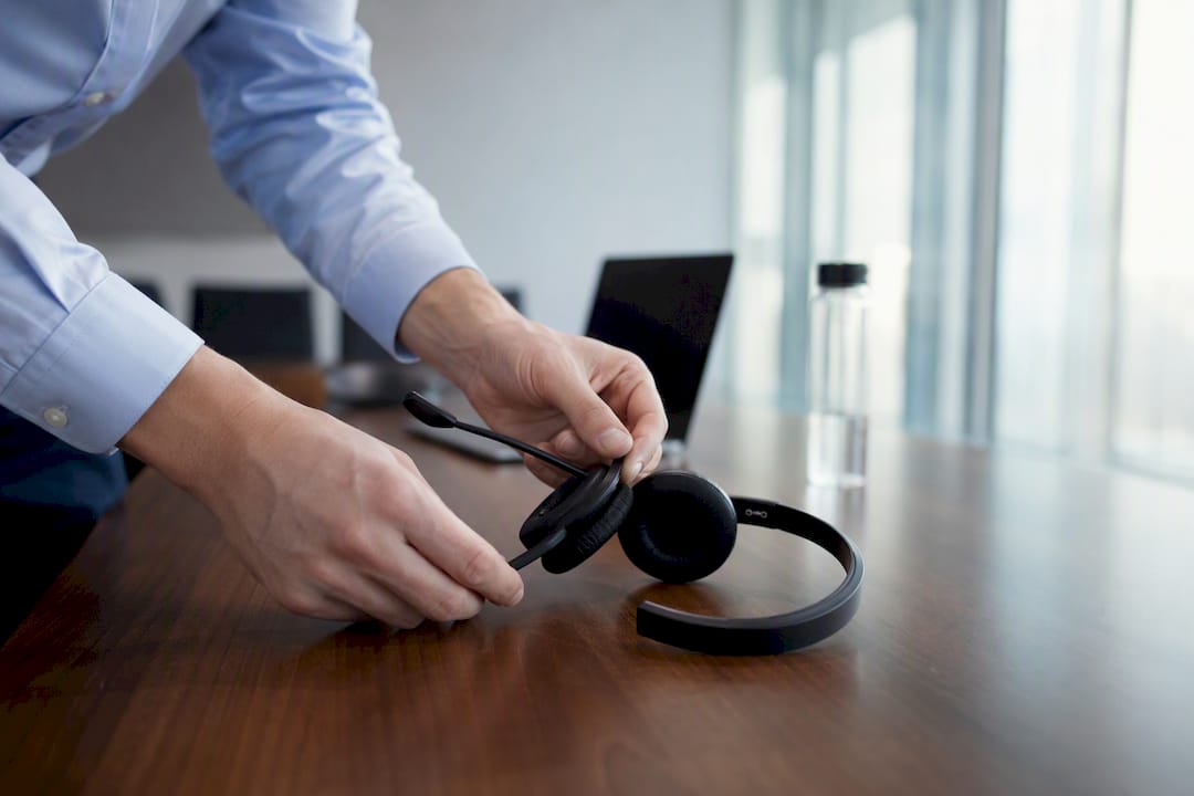 Hands adjusting headset microphone