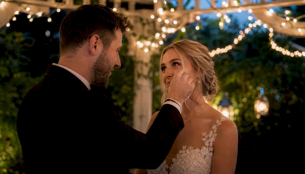 Groom brushing bride's tear in black and white
