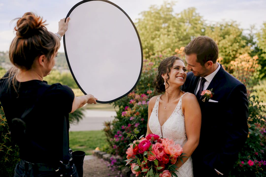 Photographer angling reflector during sunset portraits