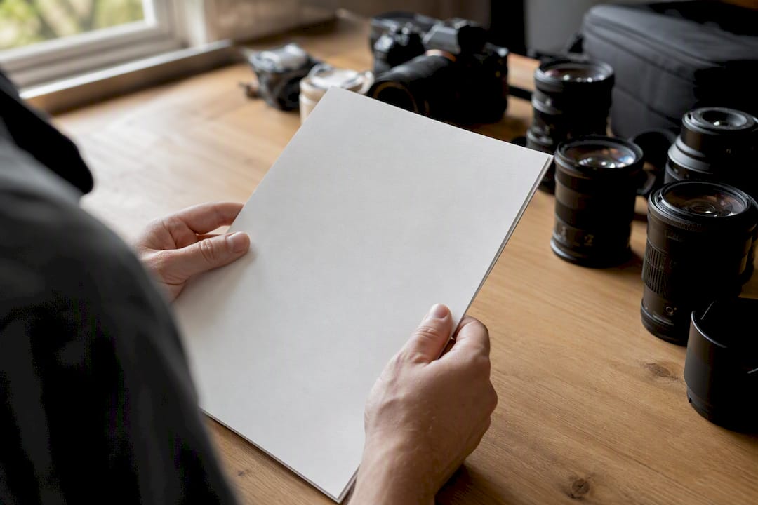 Photographer holding insurance certificate near camera gear