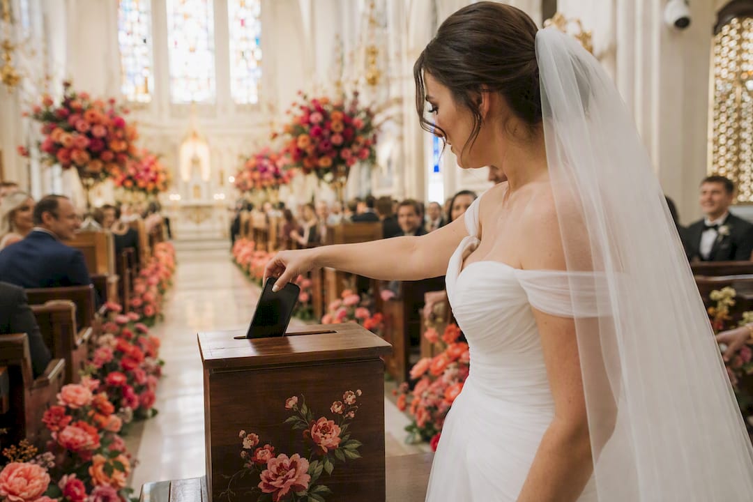 Bride placing phone into wooden drop box in chapel