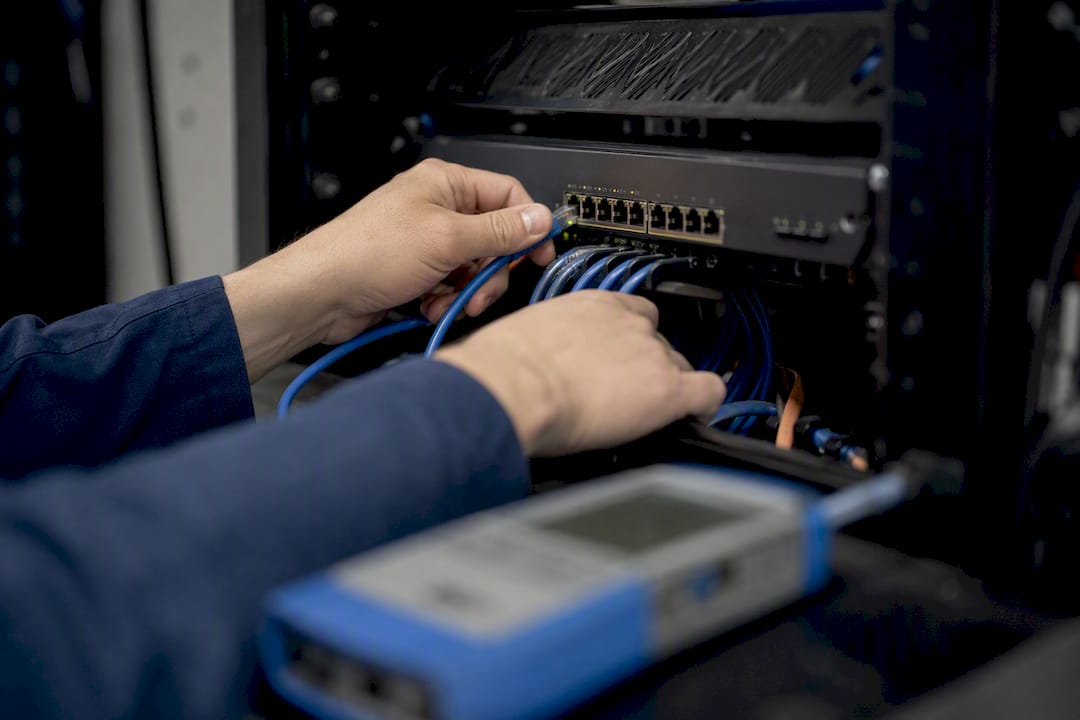 Hands connecting cables on managed network switch
